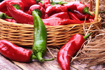 Wicker basket full of fresh red chili peppers.