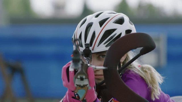 EXTREME CU Portrait of Caucasian female professional biathlete practicing on a shooting range during mid-season practice in summer. ARRI Alexa Mini with Cooke S4 prime lenses RAW graded footage