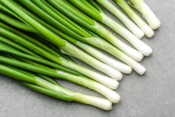 Fresh spring onions with green chive on gray background