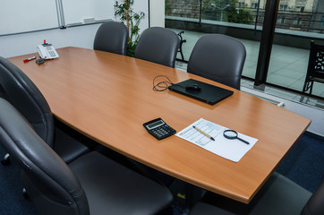 tax form 1040 on the office desk. A conference room with a table, chairs, a laptop and stationery.