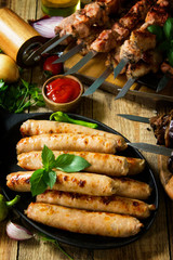 Barbecue menu. Grilled meat skewers, grilled sausages and grilled eggplant with bacon on rustic wooden table.