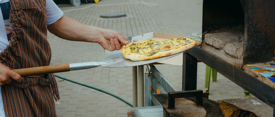 Prepared homemade pizza take out from outdoor oven.