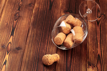 glass of wine with cork on wooden background.