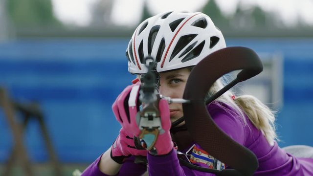 EXTREME CU Portrait of Caucasian female professional biathlete practicing on a shooting range during mid-season practice in summer. ARRI Alexa Mini with Cooke S4 prime lenses RAW graded footage