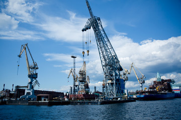 Fototapeta na wymiar cargo port cranes against blue sky