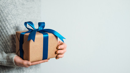 Female hands hold gift box on white background, copy space right. Unrecognizable caucasian girl in...