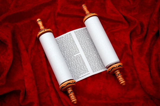 The Old Testament text, Jewish temple or synagogue, religious parchment scroll and the Judaic religion concept theme with the holy Torah open on red velvet background
