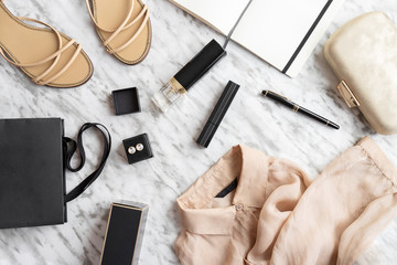 Writing a blog concept. Notebook and pen, woman accessories, clothing, shoes, bag, makeup and perfume white grey background. Fashion and Beauty flat lay.