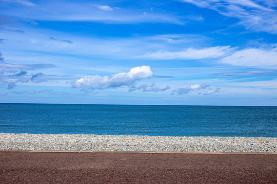 Blue Sea And Sky With Deserted Pebbled Beach In Wales UK