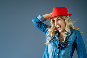 Mature woman in blue jeans and red hat