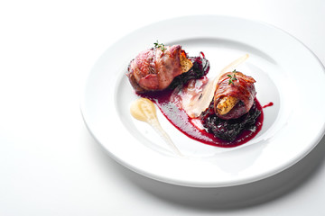  Chicken wrapped in bacon on a white plate