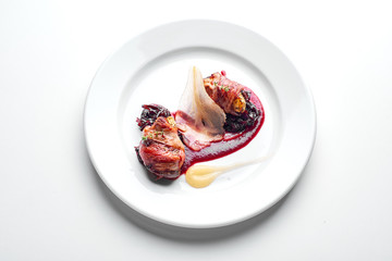  Chicken wrapped in bacon on a white plate