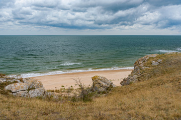 Fototapeta na wymiar The beaches of the generals of the Crimean peninsula in cloudy weather, on a sleepy day with clouds in the sky, shot during the season of golden autumn and yellow-golden brown.