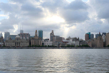 Fototapeta na wymiar wide angle view of the bund in Shanghai Puxi in daytime. Western retro buildings on the bank of Huang Pu River. Magnificent white clouds with bright sunshine