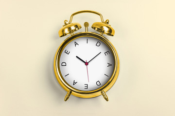Yellow Alarm Clock - Time Concept with word Idea and light yellow background