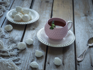 Light lunch with tea and cookies in elegant ceramic dishes and a teaspoon, the composition on the rustic unpainted table