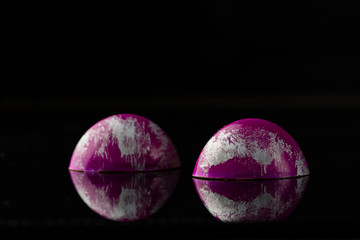 Two chocolate bonbons on black background close-up