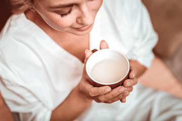 Woman enjoying her tea ceremony in massage salon.