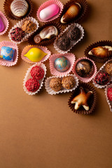 Chocolate bonbons set on brown background top view