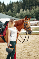 Fototapeta premium beautiful girl rider hugs a horse at the ranch.