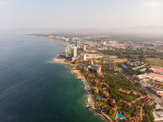 Aerial photos of the beautiful beach and town of Puerto Vallarta in Mexico, the town is on the Pacific coast in the state known as Jalisco with the mountains in the background on a cloudy day.
