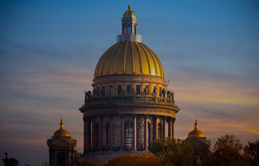 Fototapeta premium Sunset scene of Golden dome of St Isaac Cathedral over the autumnal garden