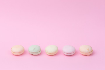 Delicate colored marshmallows on a pink background minimal style. Copy space