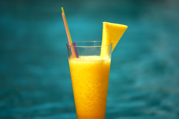 Freshly squeezed fruit pineapple orange juice on a background of the sea.