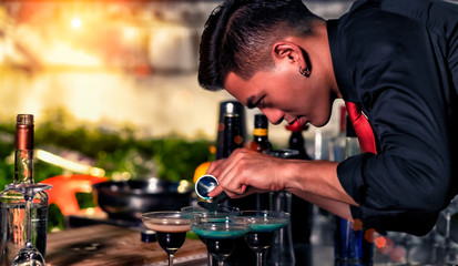 High ISO.The bartender with a cocktail is preparing a cocktail at the bar. Alcoholic beverages, people and luxury concepts.barman making cocktail at nightclub