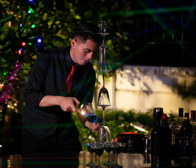 High ISO.The bartender with a cocktail is preparing a cocktail at the bar. Alcoholic beverages, people and luxury concepts.barman making cocktail at nightclub