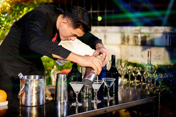 High ISO.The bartender with a cocktail is preparing a cocktail at the bar. Alcoholic beverages, people and luxury concepts.barman making cocktail at nightclub
