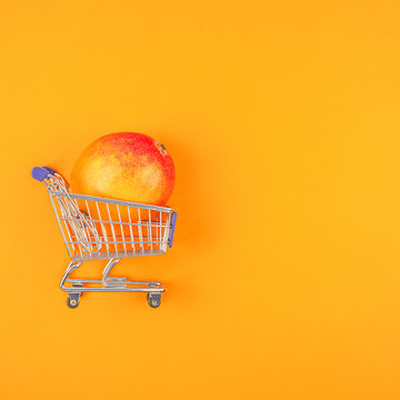 Mango Fruit In Shopping Cart On Orange Background