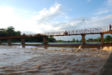 Water barrier: The brown water from the new rain passes the water barrier. Bridge over the river