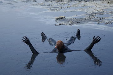 man lying in the mud