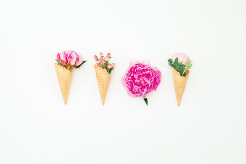 Floral concept of pink peonies, roses and waffle cones on white background. Flat lay, top view
