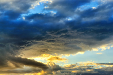 Naklejka na ściany i meble Intense sunset with massive clouds covering the sky