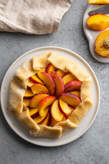 Appetite summer peach galeta on white table with copy space. summer open tart photo for cook book or food blog.