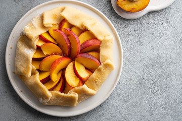 Appetite summer peach galeta on white table with copy space. summer open tart photo for cook book or food blog.
