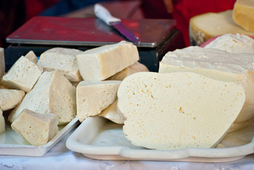Different types of cheese on the table. Many cheese is sold at an agricultural fair. Natural home product.