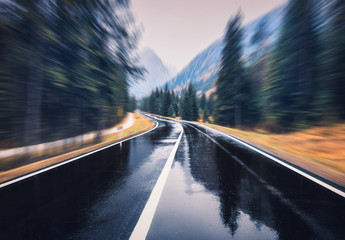 Road in the autumn forest in rain with motion blur effect. Perfect asphalt mountain road in...