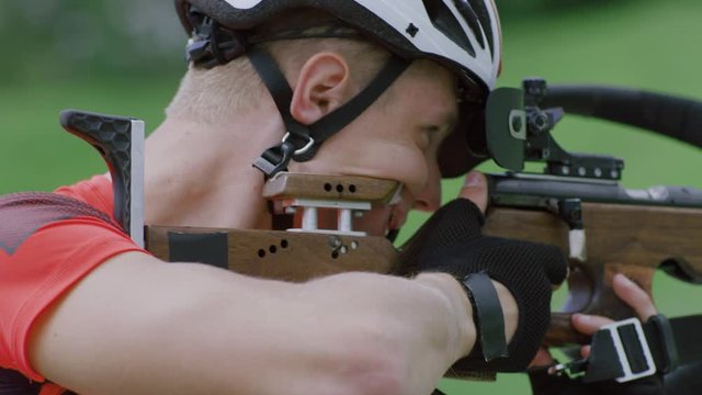 Portrait of Caucasian male professional biathlete practicing on a shooting range during mid-season practice in summer. ARRI Alexa Mini with Cooke S4 prime lenses RAW graded footage