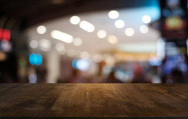 Empty dark wooden table in front of abstract blurred bokeh background of restaurant . can be used for display or montage your products.Mock up for space.