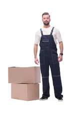 in full growth. smiling man standing near cardboard boxes