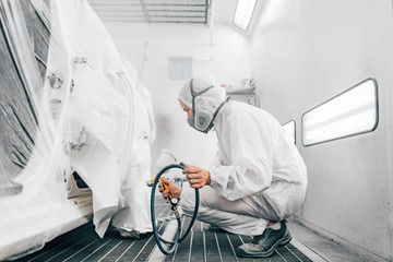 Professional car painting procedure at paint booth.