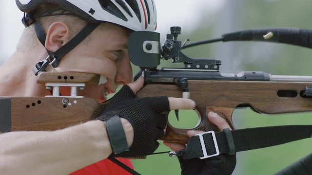 Portrait of Caucasian male professional biathlete practicing on a shooting range during mid-season practice in summer. ARRI Alexa Mini with Cooke S4 prime lenses RAW graded footage