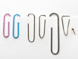 Paper clips hold paper. Needles on white background