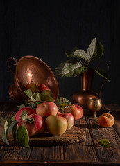 Classical still life with organic natural apples and vintage cooper decoration on old rustic wooden background. © twomeerkats