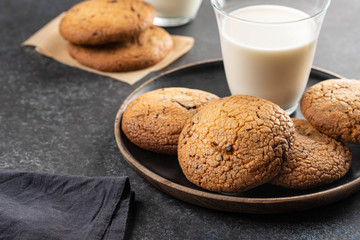 Chocolate chip cookies with milk on black table. Copy space.