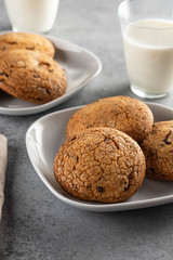 Chocolate chip cookies with milk on grey table. Copy space.