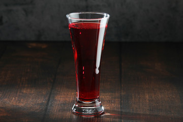 Red juicy drink in a high beer glass
